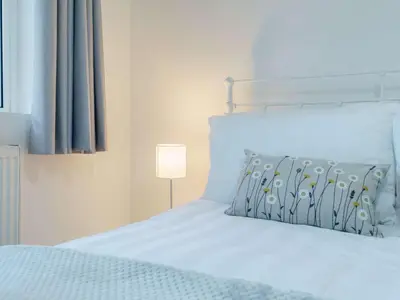 a bedroom with a white bed with a lamp at 4 Bed in Seascale oc-85807 in Gosforth