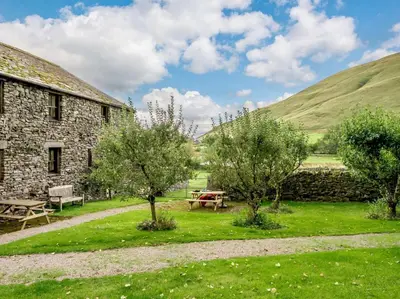 a stone building with a picnic table and trees at 1 Bed in Penrith oc-88201 in Mosedale