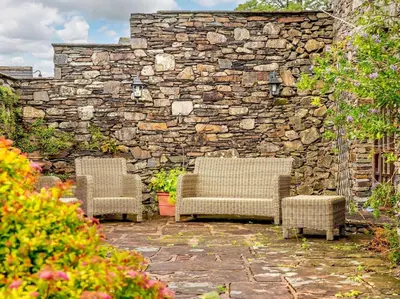two chairs and a stone wall in a garden at 3 Bed in Cockermouth oc-88773 in Buttermere