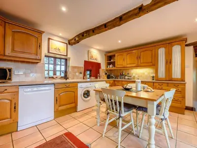 a kitchen with wooden cabinets and a table and chairs at 3 Bed in Cockermouth oc-88773 in Buttermere