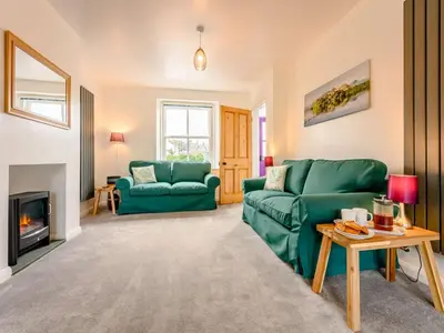a living room with two green couches and a fireplace at 2 Bed in Keswick 88864 in Keswick