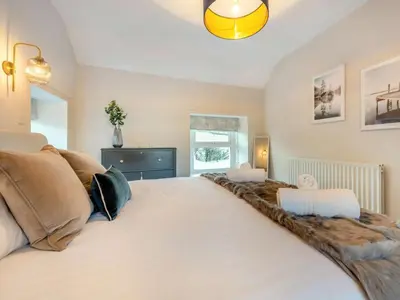 a bedroom with a large white bed and a window at 5 Bed in Wigton oc-89496 in Torpenhow