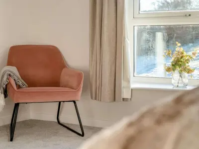 a chair sitting in a room next to a window at 5 Bed in Wigton oc-89496 in Torpenhow