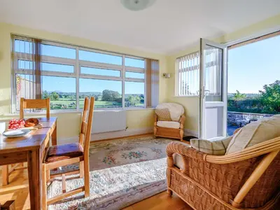 a living room with a table and chairs and windows at 3 Bed in Aspatria 89139 in Aspatria