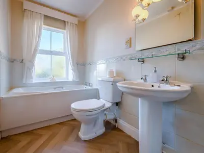 a bathroom with a toilet and a sink and a tub at 3 Bed in Aspatria 89139 in Aspatria