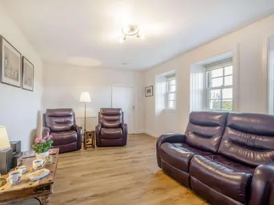 a living room with a leather couch and two chairs at 2 Bed in Ayr 90039 in Ayr