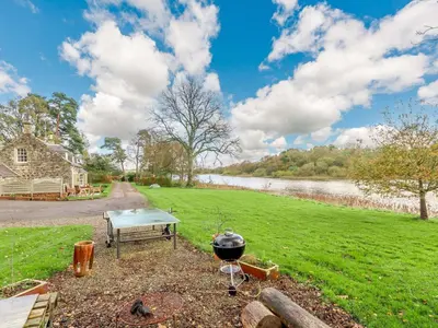 a bbq and a grill next to a river at 4 Bed in AYR 90038 in Ayr