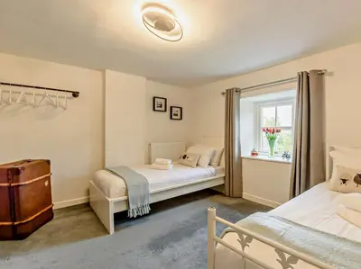 a bedroom with two beds and a window at 3 Bed in Egremont oc-90050 in Hale