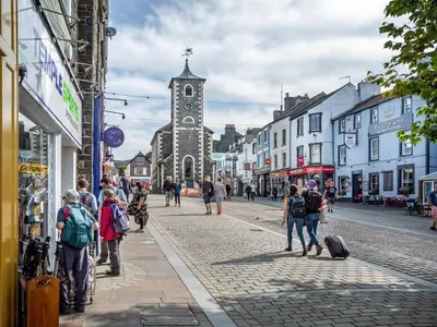 a group of people walking down a street with a church at 3 Bed in Keswick oc-90266 in Applethwaite
