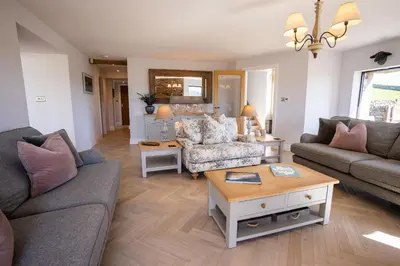 a living room with two couches and a table at Sheepfold Barn in Penruddock