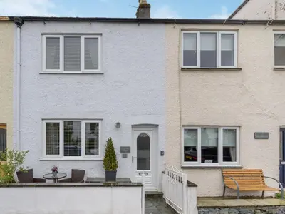 a white house with a bench in front of it at 2 Bed in Keswick oc-sz427 in Keswick