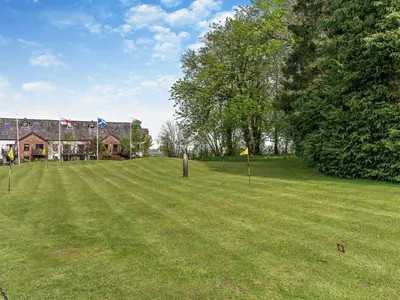 a large grass field with a house in the background at 1 Bed in Ullswater 90300 in Penruddock