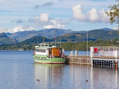 a boat is docked at a dock on a lake at 1 Bed in Ullswater 90300 in Penruddock