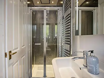 a bathroom with a sink and a glass shower at 6 Bed in Keswick oc-90333 in Keswick