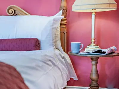 a bed with a table with a lamp and a cup at 6 Bed in Keswick oc-90333 in Keswick