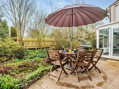 a table and chairs with an umbrella on a patio at 2 Bed in Dearham 91132 in Dearham