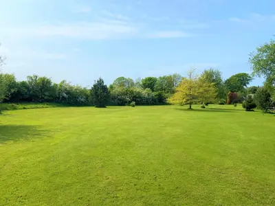 a large green field with trees in the background at 2 Bed in Dearham 91132 in Dearham