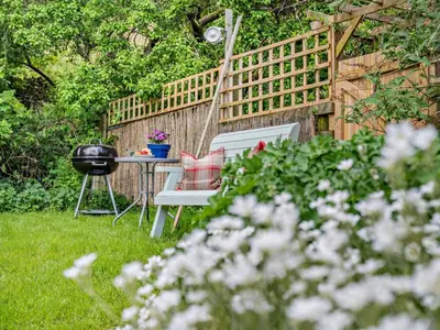a table and chairs in a garden with a fence at 1 Bed in Mosedale 91232 in Mosedale