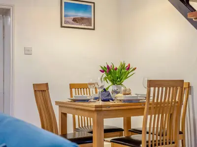 a dining room table with two chairs and a table with flowers at 2 Bed in Glenridding 90874 in Glenridding