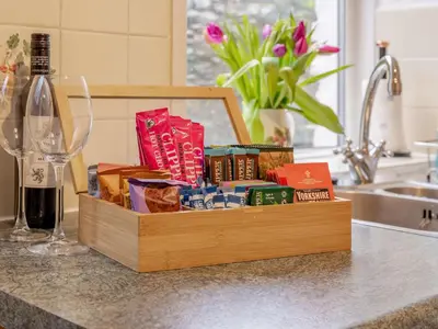 a wooden box filled with books on a counter next to a wine glass at 2 Bed in Glenridding 90874 in Glenridding