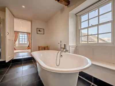 a white bath tub in a bathroom with a window at 5 Bed in Cockermouth oc-91503 in Embleton