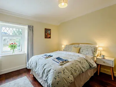 a bedroom with a bed with a vase of flowers on it at 1 Bed in Gilcrux 92218 in Gilcrux