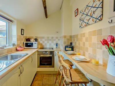 a kitchen with a counter with chairs and a sink at 1 Bed in Gilcrux 92218 in Gilcrux