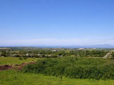 a view of a field of grass with mountains in the background at 1 Bed in Gilcrux 92218 in Gilcrux