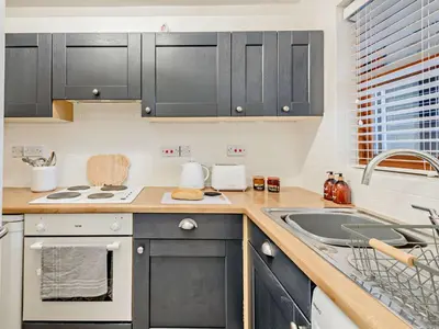 a kitchen with black cabinets and a sink at 2 Bed in Keswick 91901 in Keswick
