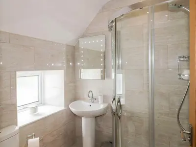 a bathroom with a sink and a shower at Haven Cottage in Kirkcudbright