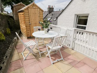 a table and chairs on a patio with a fence at Haven Cottage in Kirkcudbright
