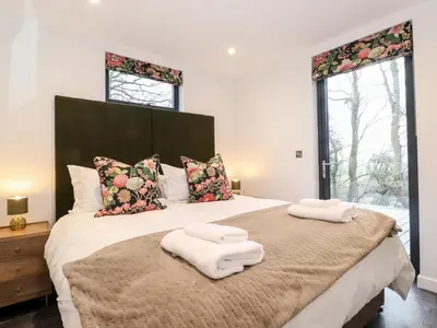 a bedroom with a large bed with two towels on it at Herdwick Cabin in Penrith