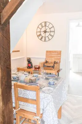 a dining room with a table with chairs and a clock at Charming Cottage, Lake District in Little Broughton