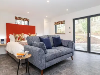 a living room with a couch and a bed at The Gardener's Retreat in Penrith