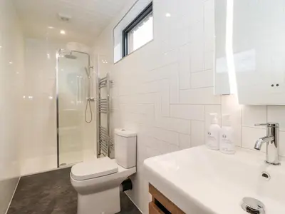 a bathroom with a toilet and a shower and a sink at The Gardener's Retreat in Penrith