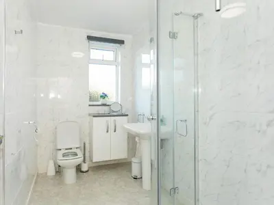 a bathroom with a toilet and a sink and a shower at High Auchenlarie Cottage in Carsluith