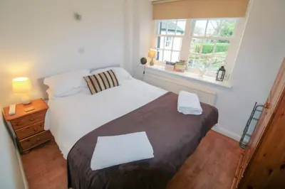 a bedroom with a large bed and a window at Emilys Nook Ireby, budget accommodation with fell views in Ireby