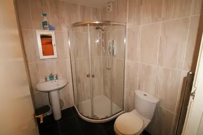 a bathroom with a shower and a toilet and a sink at Emilys Nook Ireby, budget accommodation with fell views in Ireby