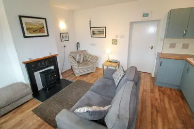a living room with a couch and a fireplace at Emilys Nook Ireby, budget accommodation with fell views in Ireby