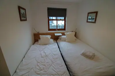 a bedroom with two beds with white sheets and a window at Glenmore, Hewetson Court, centrally located 1st floor apartment in Keswick in Keswick
