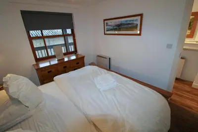 a bedroom with a white bed and a window at Glenmore, Hewetson Court, centrally located 1st floor apartment in Keswick in Keswick