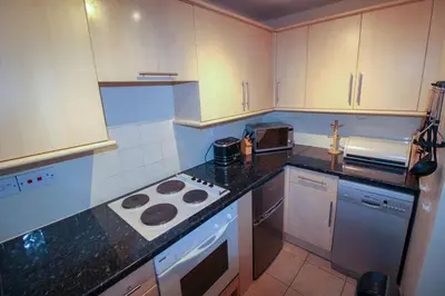 a kitchen with a stove and a counter top at Glenmore, Hewetson Court, centrally located 1st floor apartment in Keswick in Keswick