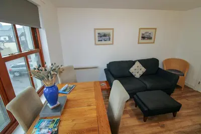 a living room with a couch and a table at Glenmore, Hewetson Court, centrally located 1st floor apartment in Keswick in Keswick