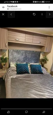a bedroom with a large bed with two blue pillows at Birds Eye View in Mainsriddle