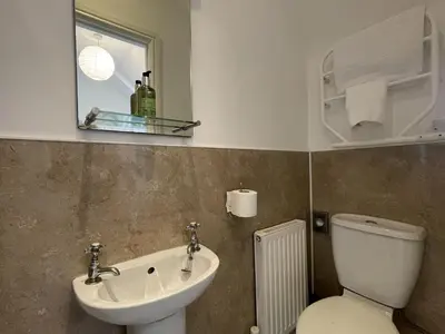 a bathroom with a sink and a toilet and a mirror at Ellergill in Keswick