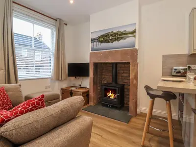 a living room with a fireplace and a couch at Jack's Cottage in Keswick