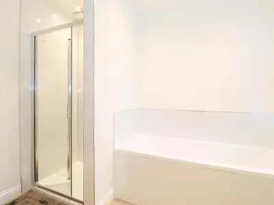 a bathroom with a shower and a mirror at Jack's Cottage in Keswick
