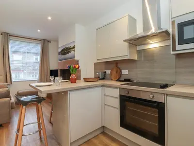 a kitchen with white cabinets and a counter top at Jack's Cottage in Keswick