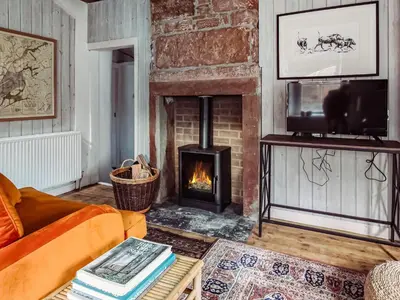 a living room with a fireplace and a couch at Top Lodge in Carlisle