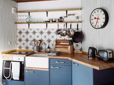 a kitchen with blue cabinets and a clock on the wall at Top Lodge in Carlisle